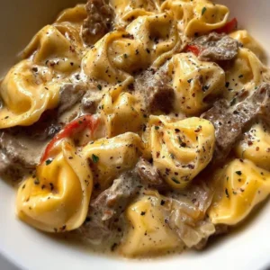 A bowl of Philly Cheesesteak Tortellini pasta with cheese and peppers